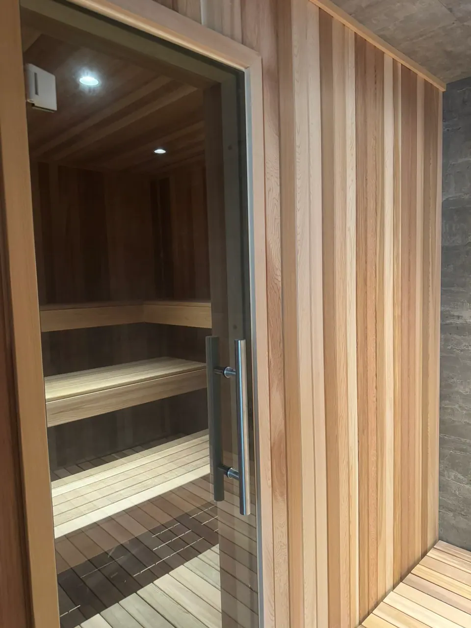 Indoor sauna with a full-glass front and door