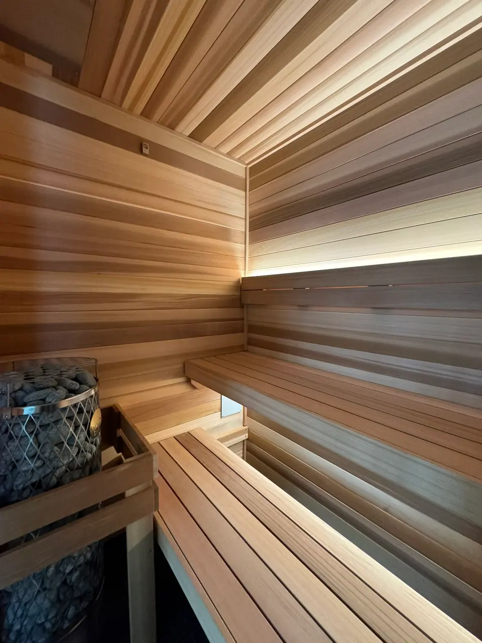 Indoor sauna with LED-lit backrest and an electric heater