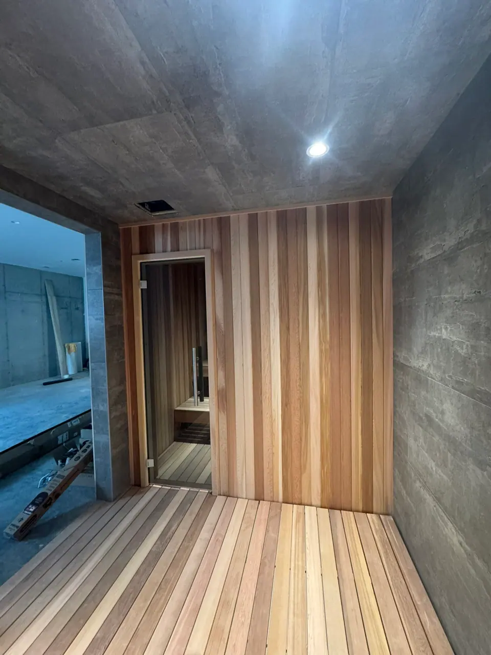 Indoor sauna entry with cedar slat flooring and tile walls