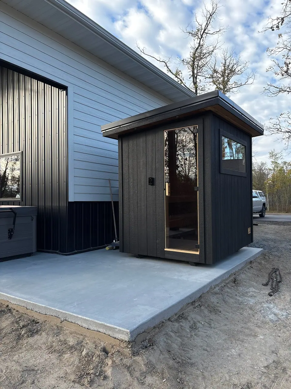 Kota sauna set on a new concrete pad next to a garage