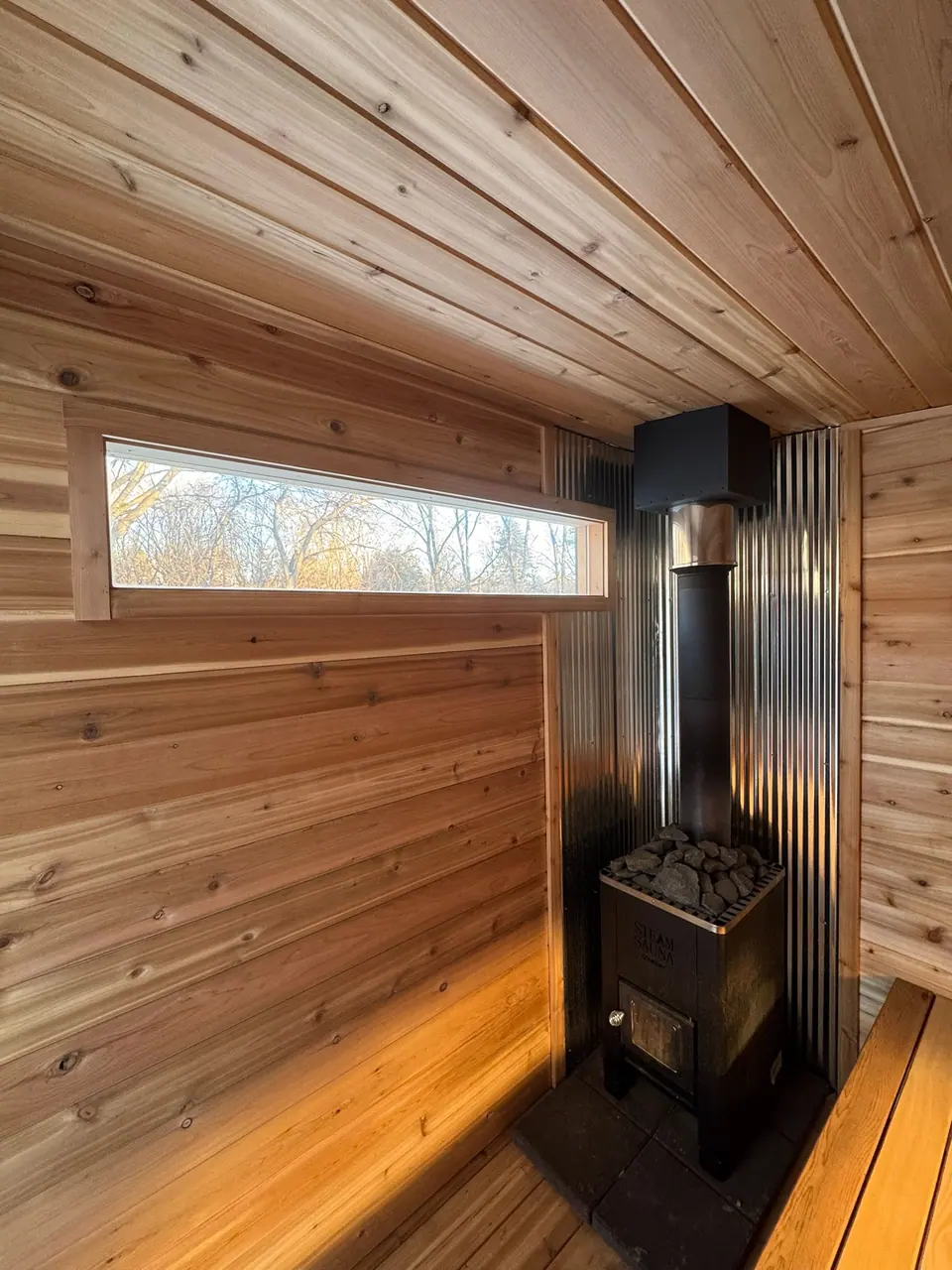 Kota sauna interior with bench lighting and a long window above the top bench