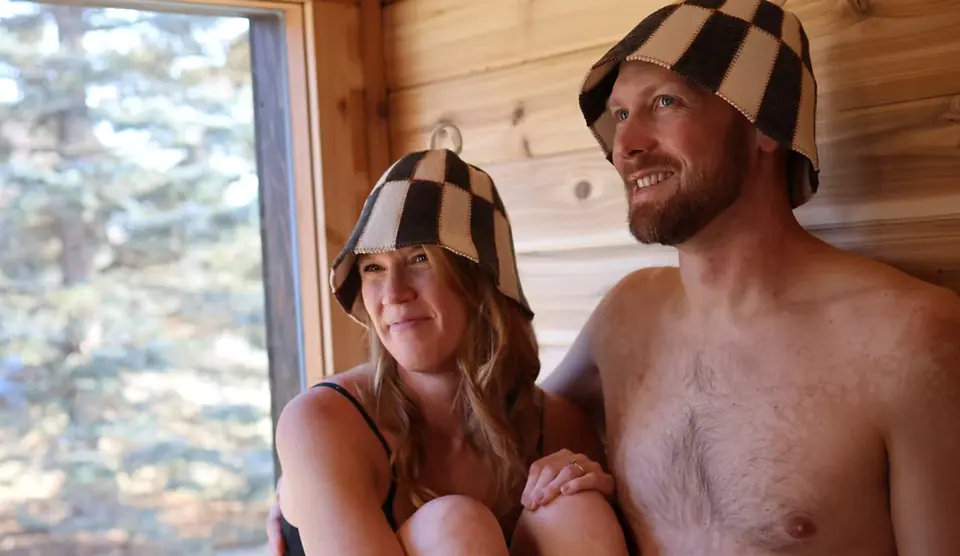 Two guests in sauna hats inside the Tuli at Nordic Escape
