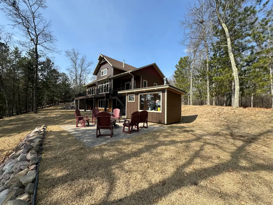 Superior sauna beside a lake home with chairs set around a fire pit