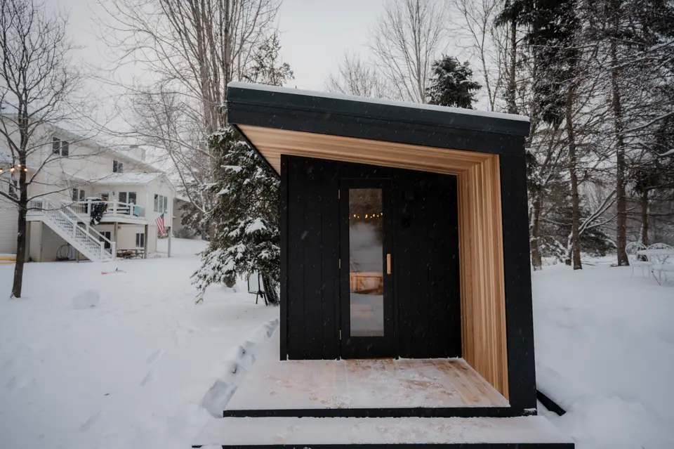 Front of the Tuli sauna in daylight, cedar entry and full-glass door