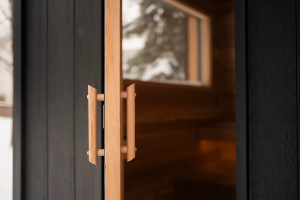 Wood door handles on the full-glass sauna door