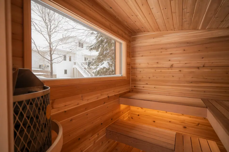 Inside the Tuli sauna: cedar benches, the stove and a wide window