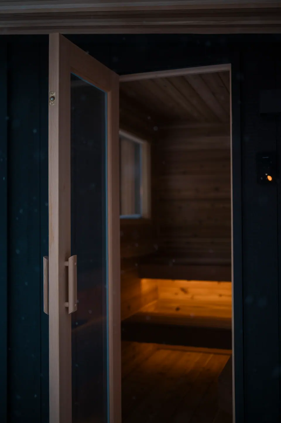 Looking in through the open sauna door at night, benches lit from below